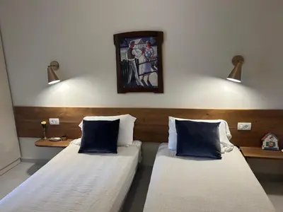 two beds in a room with a painting on the wall at Private Patio Przno Steps to Beach 2 Bedroom 2 Parkings BBQ Villa Olive in Sveti Stefan