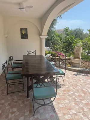 a wooden table and chairs on a patio at Private Patio Przno Steps to Beach 2 Bedroom 2 Parkings BBQ Villa Olive in Sveti Stefan