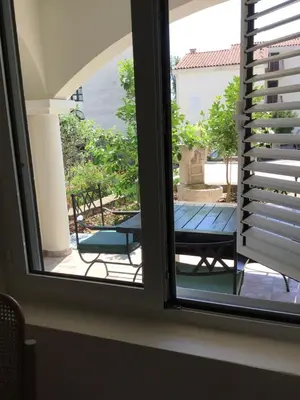 a window with a view of a table and a bench at Private Patio Przno Steps to Beach 2 Bedroom 2 Parkings BBQ Villa Olive in Sveti Stefan