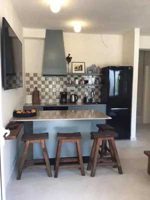a kitchen with a counter with stools and a black refrigerator at Private Patio Przno Steps to Beach 2 Bedroom 2 Parkings BBQ Villa Olive in Sveti Stefan