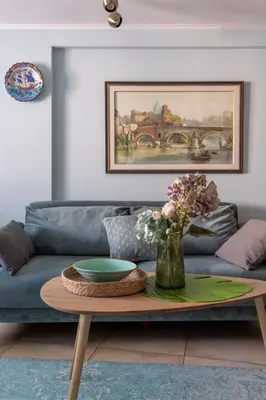 a living room with a couch and a table with flowers at Centre Budva Blue in Budva
