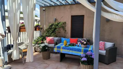 a patio with a couch and flowers on a patio at Centre Budva Blue in Budva