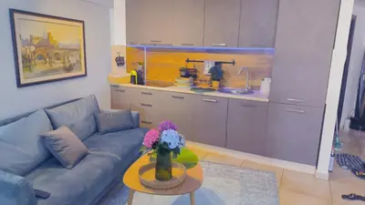 a living room with a couch and a table with flowers at Centre Budva Blue in Budva