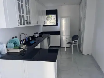 a kitchen with white cabinets and a black counter top at ALOHA Beach front Vacation Rental in Ulcinj
