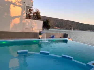 a large swimming pool with a water fountain at ALOHA Beach front Vacation Rental in Ulcinj