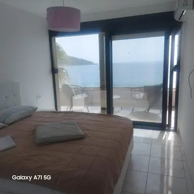 a bedroom with a bed and a view of the ocean at ALOHA Beach front Vacation Rental in Ulcinj