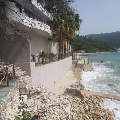 a building on a rocky beach next to the ocean at ALOHA Beach front Vacation Rental in Ulcinj