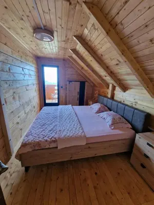 a bedroom with a bed in a wooden house at Bungalovi Spahic in Ulcinj