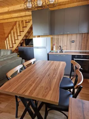 a kitchen with a wooden table and chairs at Bungalovi Spahic in Ulcinj