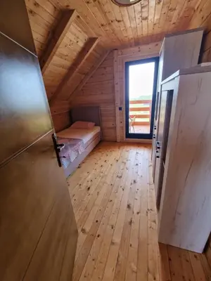 a room in a log cabin with a bed and a window at Bungalovi Spahic in Ulcinj