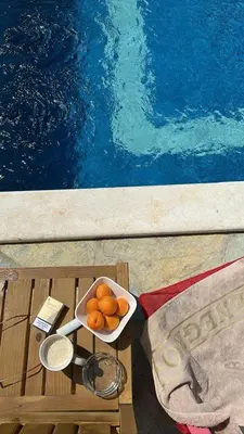 a bowl of oranges on a table next to a pool at Bungalovi Spahic in Ulcinj