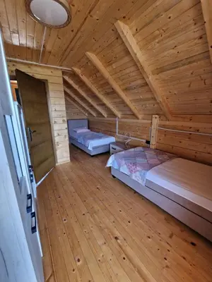 a room with two beds and a wooden ceiling at Bungalovi Spahic in Ulcinj