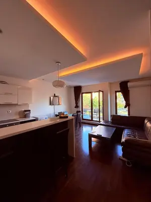 a kitchen and a living room with a couch at The Budva Apartment in Budva