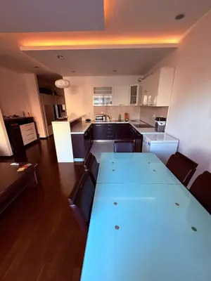 a kitchen with a large white table in a room at The Budva Apartment in Budva