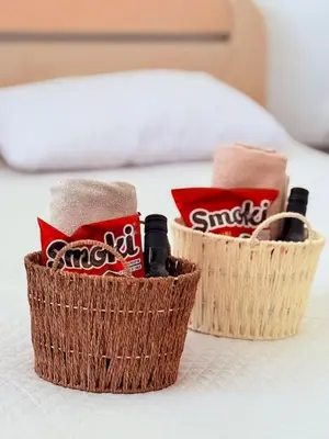 two baskets on a bed with towels and soda at The Budva Apartment in Budva