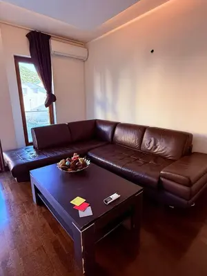 a living room with a brown leather couch and a table at The Budva Apartment in Budva