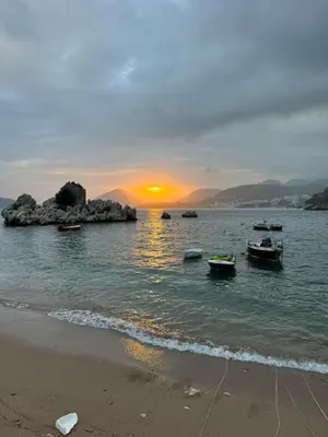 a sunset over a beach with boats in the water at Sea view steps to Przno beach 2 Bedrooms Terrace Parking Villa Olive in Sveti Stefan