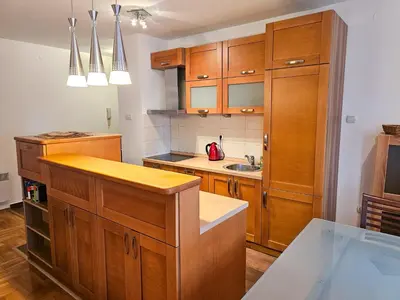 a kitchen with wooden cabinets and a sink at Luka's Blok 9 Apartment in Podgorica