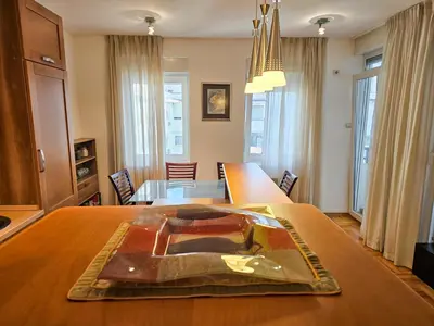 a dining room with a large wooden table with a table at Luka's Blok 9 Apartment in Podgorica