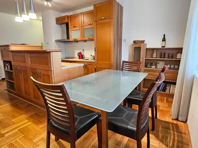 a kitchen with a glass table and two chairs at Luka's Blok 9 Apartment in Podgorica