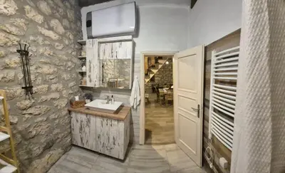 a bathroom with a sink and a stone wall at Holiday home Zlatna Glavica in Podgorica