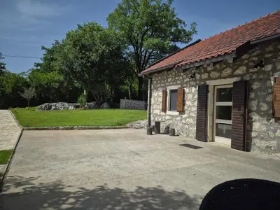 a stone house with a driveway in front of it at Holiday home Zlatna Glavica in Podgorica