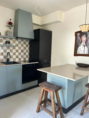 a kitchen with a counter and a island with stools at Steps to beach 3 Bedrooms 2 Bathrooms 2 Kitchens with a Terrace - 2 Parking spots - Sea View in Sveti Stefan