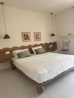 a bedroom with a large bed with white sheets at Steps to beach 3 Bedrooms 2 Bathrooms 2 Kitchens with a Terrace - 2 Parking spots - Sea View in Sveti Stefan