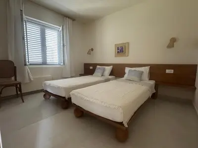 a bedroom with two beds and a window at Steps to beach 3 Bedrooms 2 Bathrooms 2 Kitchens with a Terrace - 2 Parking spots - Sea View in Sveti Stefan