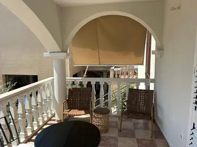 a balcony with two chairs and an archway at Steps to beach 3 Bedrooms 2 Bathrooms 2 Kitchens with a Terrace - 2 Parking spots - Sea View in Sveti Stefan