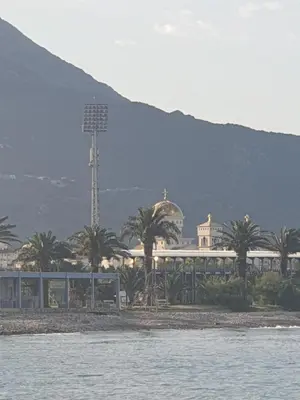 a building with palm trees in front of the water at Montenegrinbeautystar in Bar
