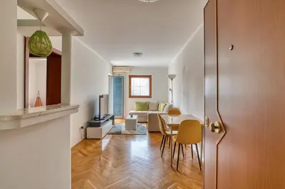 a kitchen and living room with a table and chairs at M Apartment Budva in Budva