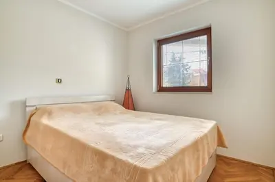 a bedroom with a large bed with a window at M Apartment Budva in Budva