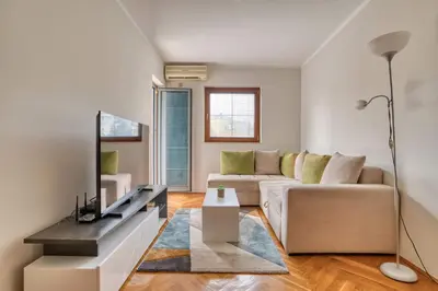 a living room with a couch and a table at M Apartment Budva in Budva