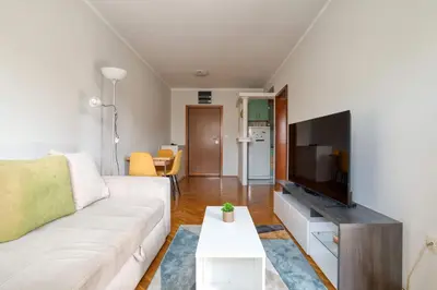a living room with a white couch and a flat screen tv at M Apartment Budva in Budva
