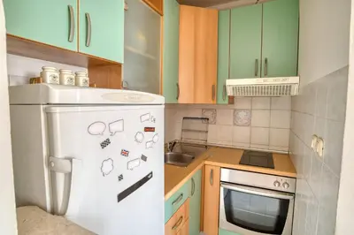 a kitchen with green cabinets and a white refrigerator at M Apartment Budva in Budva