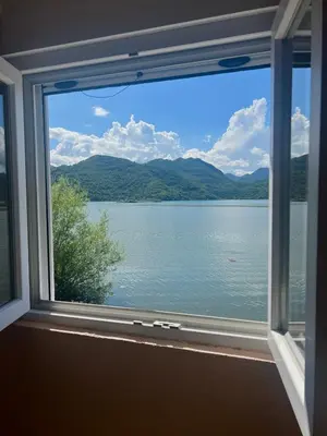 a window with a view of a lake at Lakeside Harmony Apartment in Golubovci