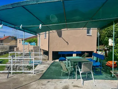 a patio with a table and chairs under a tent at Lakeside Harmony Apartment in Golubovci