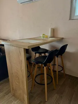 a wooden table with four chairs and a counter top at Lakeside Harmony Apartment in Golubovci