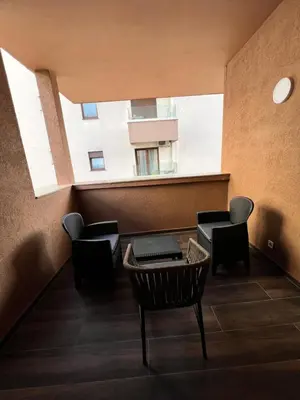 a balcony with chairs and a table and a building at Agatom in Budva