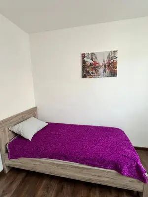 a bedroom with a purple bed with a picture on the wall at Agatom in Budva