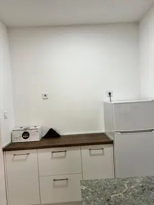 a kitchen with white cabinets and a white refrigerator at Agatom in Budva