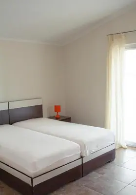 a bedroom with two beds and a window at Apartmani Marina in Sutomore