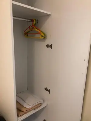 a bathroom with a white closet with towels in it at Apartmani Marina in Sutomore