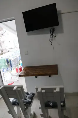 a living room with two chairs and a tv on the wall at Smještaj Milena Čanj in Čanj