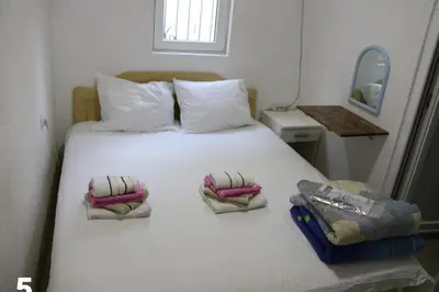 a bedroom with a white bed with two pillows and a mirror at Smještaj Milena Čanj in Čanj