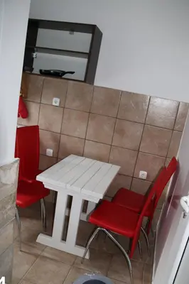 a white table and red chairs in a room at Smještaj Milena Čanj in Čanj