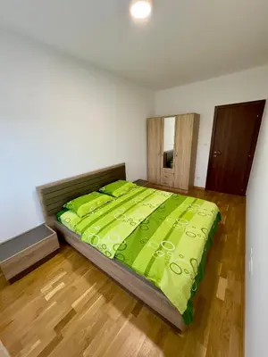 a bedroom with a large bed with a green comforter at Cozy 1 bedroom APT with free parking in Podgorica