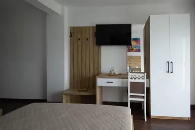 a bedroom with a bed and a desk and a kitchen at GAVIA Apartments - Ulcinj in Ulcinj