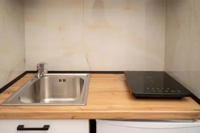 a kitchen with a sink and a laptop on a counter at GAVIA Apartments - Ulcinj in Ulcinj